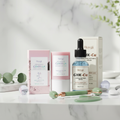 Skin Reset Bundle — clay mask, copper peptides serum, and jade roller on marble background
